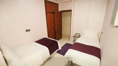 a bedroom with two beds and a door to another room at Darkoum, your apartment in fes city in Fès
