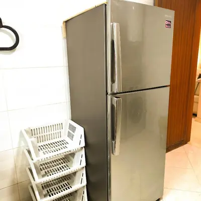 a stainless steel refrigerator in a kitchen with white baskets at Darkoum, your apartment in fes city in Fès