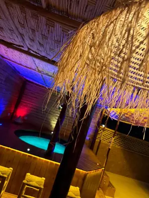 a small pool with a straw umbrella and chairs at Paradise luxe in Fès