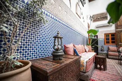a living room with a couch and blue and white tiles at Riad Dar Tahri & SPA in Fès