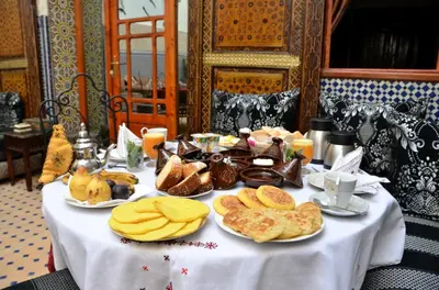 a table with plates of food and bread on it at Riad Dar Tahri & SPA in Fès