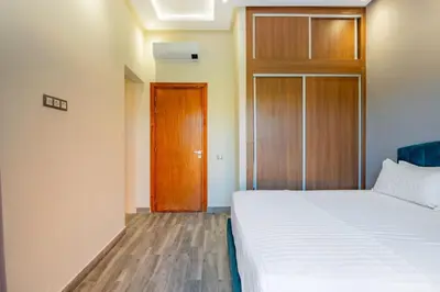 a bedroom with a bed and a wooden door at Villa de Luxe Ouidane 5 Chambres in Marrakech