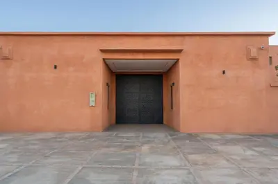 a large orange building with a black door at Villa de Luxe Ouidane 5 Chambres in Marrakech