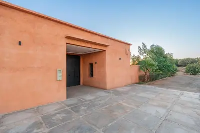 an orange building with a large parking lot at Villa de Luxe Ouidane 5 Chambres in Marrakech