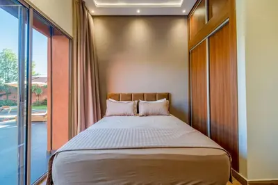 a bed in a room with a large window at Villa de Luxe Ouidane 5 Chambres in Marrakech