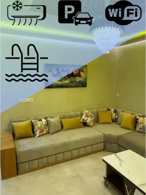 a living room with a couch and a table at Appartement Cosy avec piscine à Khenifra in Khenifra