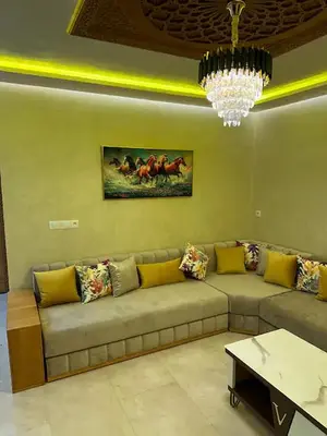 a large couch in a living room with a chandelier at Appartement Cosy avec piscine à Khenifra in Khenifra