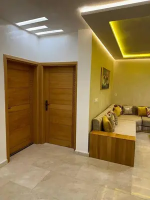 a living room with a couch and two wooden doors at Appartement Cosy avec piscine à Khenifra in Khenifra