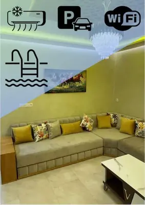 a living room with a couch and a table at Appartement Cosy avec piscine à Khenifra in Khenifra