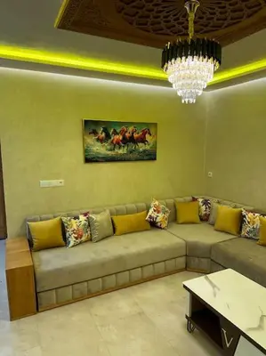 a living room with a couch and a chandelier at Appartement Cosy avec piscine à Khenifra in Khenifra