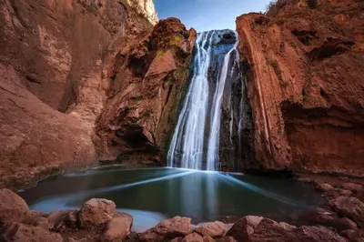a waterfall in a canyon with a pool of water at Appartement Cosy avec piscine à Khenifra in Khenifra