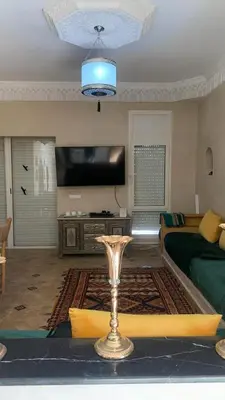 a living room with a bed and a table with a wine glass at فيلا جنة النخيل in Marrakech