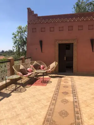 a patio with two chairs and a table in front of a building at Jamarou in Marrakech