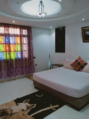 a bedroom with a bed and a colorful window at Jamarou in Marrakech