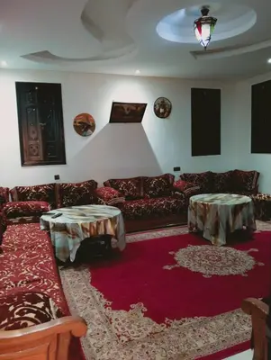 a living room with couches and tables on a red rug at Jamarou in Marrakech