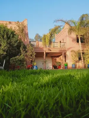 a house with a yard with green grass at Jamarou in Marrakech
