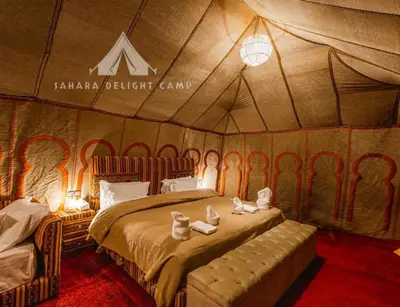 a bedroom with a bed in a tent at Sahara Delight Camp in Merzouga