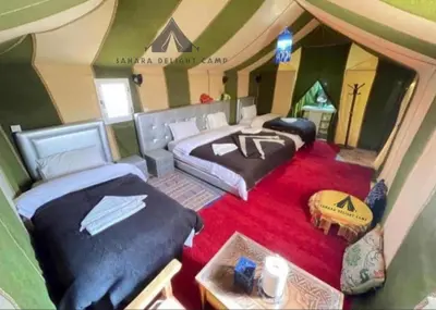 a room with two beds in a tent at Sahara Delight Camp in Merzouga