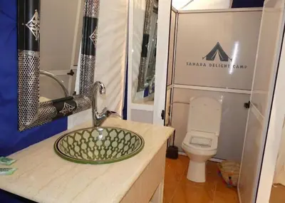a bathroom with a sink and a toilet at Sahara Delight Camp in Merzouga