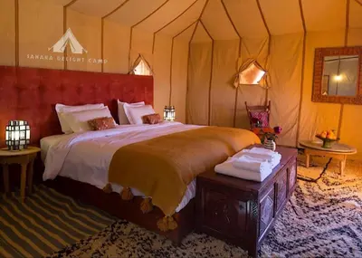 a bedroom with a large bed in a tent at Sahara Delight Camp in Merzouga