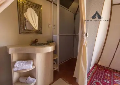 a bathroom with a sink and a mirror and a shower at Sahara Delight Camp in Merzouga