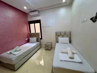 two beds in a room with towels on them at Dar Fes Medina - Guest Rooms in Fès