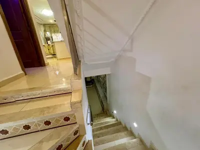 a stairway with wooden steps and a white wall at Dar Fes Medina - Guest Rooms in Fès