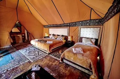 a bedroom with two beds in a tent at Adrar desert camp in Merzouga