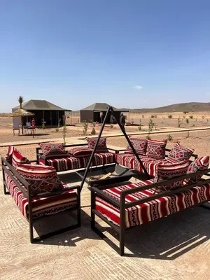 a group of beds in the middle of the desert at Andromeda Desert Astro Camp in Derkaoua