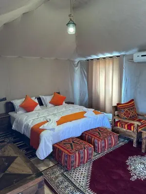 a bedroom with a large bed in a tent at Andromeda Desert Astro Camp in Derkaoua