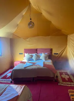 a bedroom with a bed in a tent at Andromeda Desert Astro Camp in Derkaoua