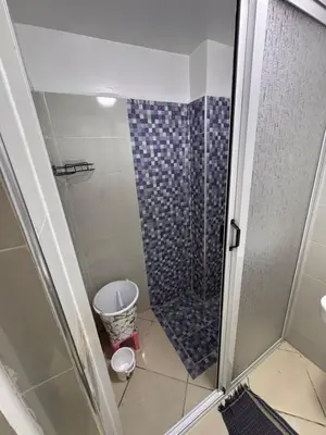 a shower with a glass door in a bathroom at appartement a jawharat atlass 2 in Beni Mellal
