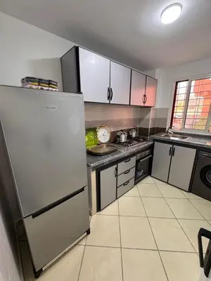 a kitchen with a stainless steel refrigerator and counters at appartement a jawharat atlass 2 in Beni Mellal