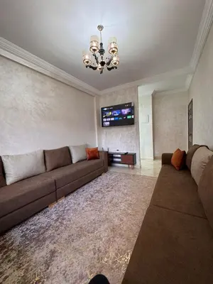 a living room with a couch and a tv at appartement a jawharat atlass 2 in Beni Mellal