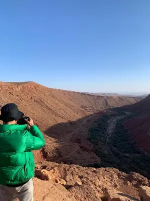 a man taking a picture of a canyon at Ounilla valley in Tizgui nʼBarda