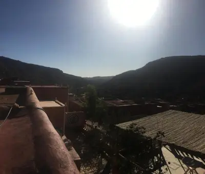 a view of a city with the sun in the sky at Ounilla valley in Tizgui nʼBarda