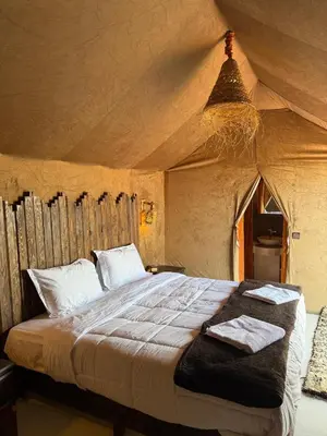 a bedroom with a bed in a tent at Mountain luxury camps in Merzouga