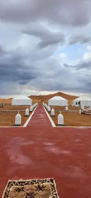 a row of white tents in a desert field at Mountain luxury camps in Merzouga