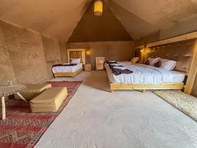 a bedroom with two beds and a couch in a room at Mountain luxury camps in Merzouga