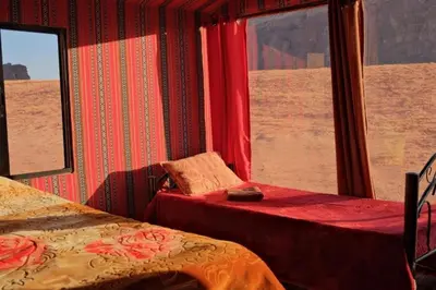 a bedroom with two beds and a view of the desert at merzouga desert camp in Merzouga