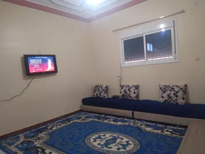 a living room with a couch and a tv at شقة للكراء اليومي بمركز تنغير in Tinerhir