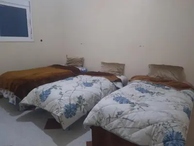 two beds sitting next to each other in a room at شقة للكراء اليومي بمركز تنغير in Tinerhir