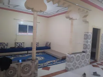 a living room with a couch and a bed in a room at شقة للكراء اليومي بمركز تنغير in Tinerhir