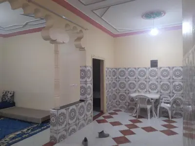 a room with a table and chairs and a bed at شقة للكراء اليومي بمركز تنغير in Tinerhir