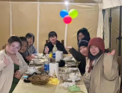 a group of people sitting at a dinner table at Desert Nights Camp in Merzouga