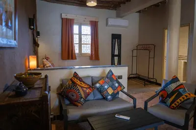 a living room with a couch with pillows on it at Ksar Sania - Merzouga in Merzouga