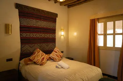 a bedroom with a bed with two pillows on it at Ksar Sania - Merzouga in Merzouga