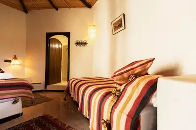 a bedroom with two beds in a room at Ksar Sania - Merzouga in Merzouga
