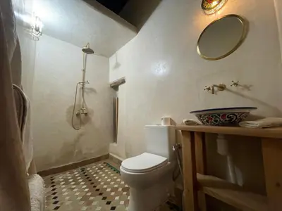 a bathroom with a toilet and a sink and a mirror at Rooms in Dar Drouj, a special 14th century house Riad in Fès