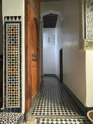 a hallway with a tiled floor and a door at Rooms in Dar Drouj, a special 14th century house Riad in Fès